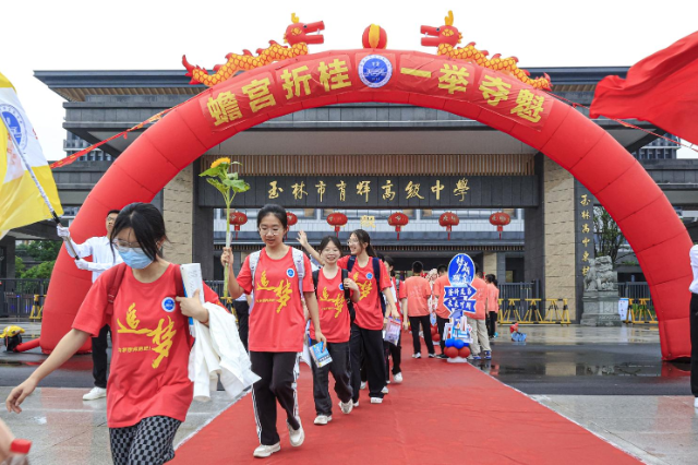 玉林市育輝高級中學紅毯鋪地，紅聯(lián)掛樓，為勇士出征高考助威祝福。在一片助威聲中，育園學子目光如炬，步伐堅定，意氣風發(fā)地邁過狀元門，斗志昂揚地出征高考。（陳穎強  周家名）.png