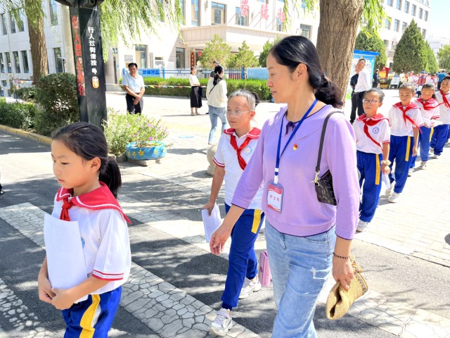 02 臨澤縣城關(guān)小學“紅燭先鋒”護學崗教師護送學生放學。謝靜 攝.jpg