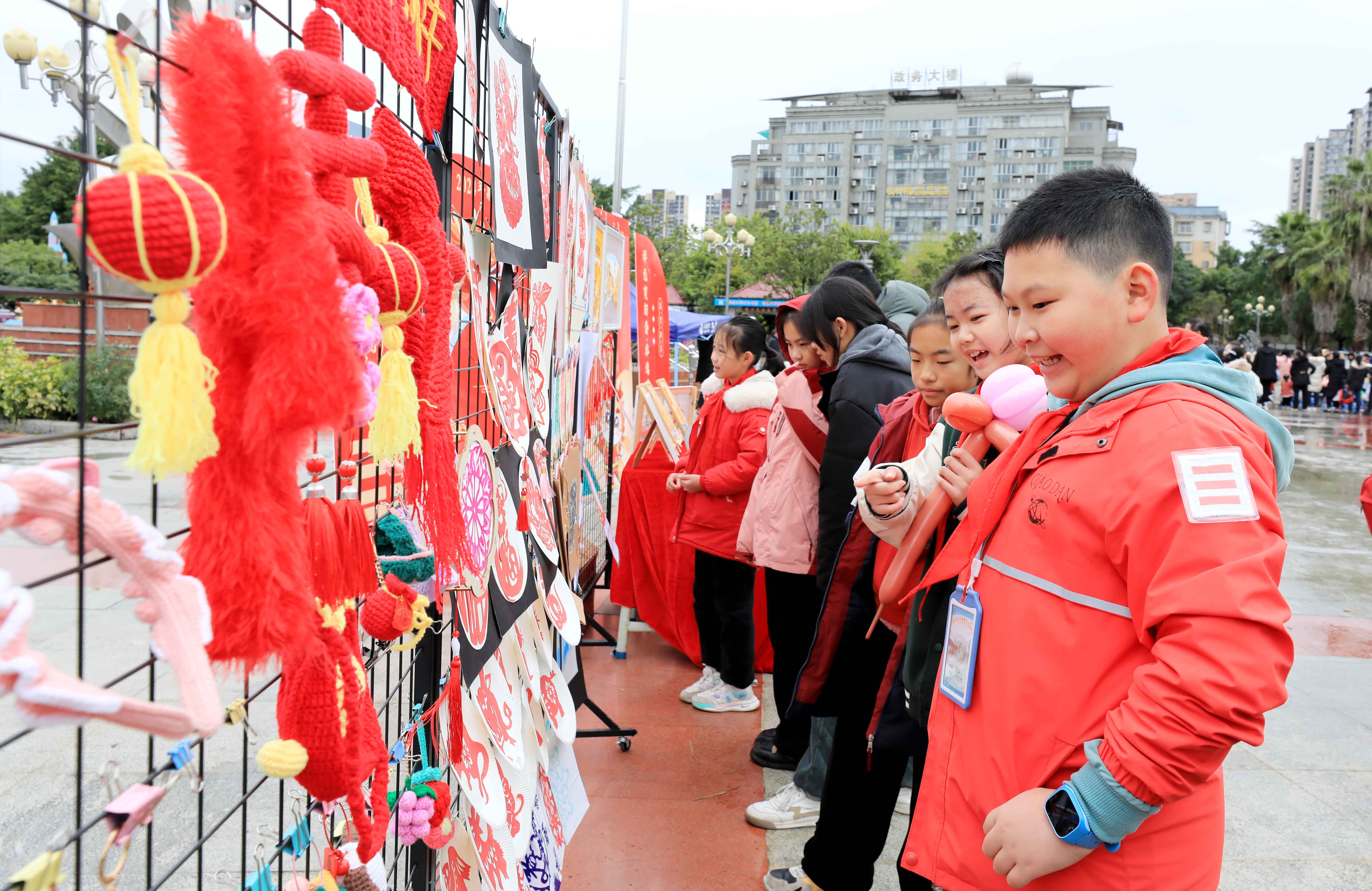 圖7：1月20日，在廣西柳州市融安縣長(zhǎng)安廣場(chǎng)，學(xué)生在非遺集市上選購(gòu)作品。（譚凱興 攝）.JPG